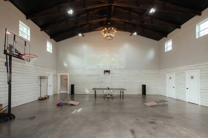 gathering area in the barn with ping pong, basketball and corn hole and a seating area